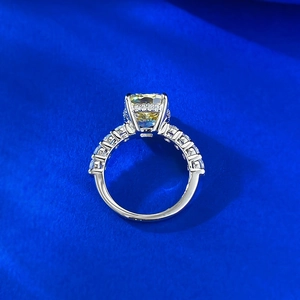 Luxurious yellow cushion cut ring with diamond halo on blue textured fabric