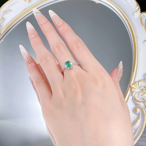 Close-up of S925 silver emerald cut green gemstone ring with sparkling diamond accents