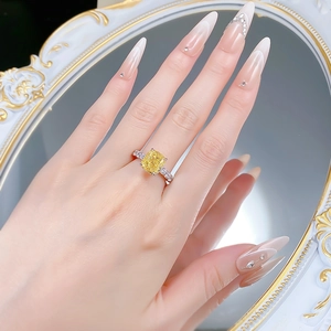 Macro shot of cushion-cut yellow gemstone ring with pavé diamonds on a silver band