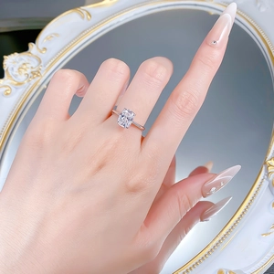 Macro detail of rectangle-cut sparkling solitaire ring on a hand with vintage mirror background