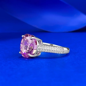 Macro side view of an oval pink gem ring with side-set micro-paved white stones