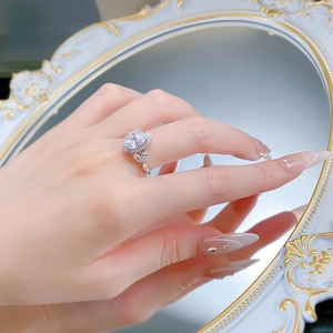 Gros plan d'une bague en argent avec diamant poire de 3 carats portée à la main