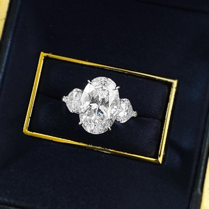 Classic S925 silver oval cut three-stone ring on dark blue velvet jewelry box