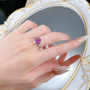 Close-up of a luxury S925 silver ring with a large pink dry rose stone on a model hand