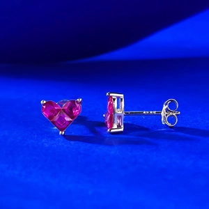 Macro view of S925 silver heart stud earrings with vibrant red gemstone inlay
