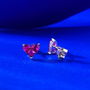 Macro detail of S925 sterling silver heart stud earrings with magenta crystal stones