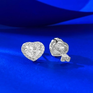 Macro shot of S925 sterling silver heart earrings with halo diamonds and luxury finish
