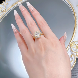 Close-up of luxury gold-plated silver ring with oval cubic zirconia on woman's finger