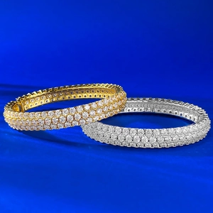 Luxurious gold and silver bracelets with full pave set crystals on deep blue background