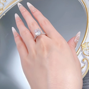 Detail of 5-carat cushion-cut high carbon diamond ring on hand with pavé band detail