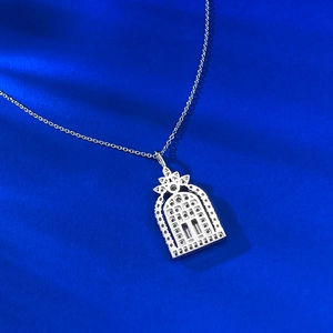 Macro detail of S925 silver castle pendant with zircon stones on blue velvet background