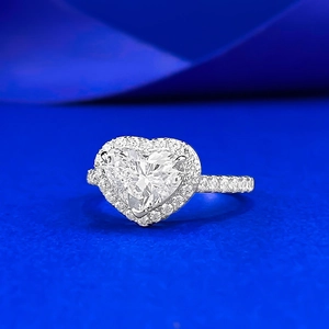 Bague en argent S925 avec diamant taille cœur et pavé sur fond satiné bleu