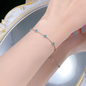 Close-up of S925 silver bracelet with blue gemstones worn on wrist near a mirror