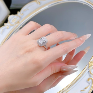 Vue détaillée d'une bague taille émeraude avec double halo et pavé sur un miroir