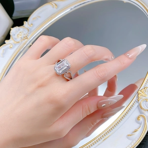 Nahaufnahme eines 6-Karat-Rings im Smaragdschliff mit doppelreihigem Diamantbesatz