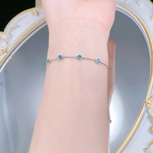 Detail of S925 silver bracelet featuring five round-cut turquoise stones on a slim chain