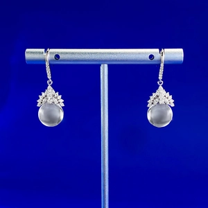 Détail de boucles d'oreilles en argent S925 avec cristaux et pierres de lune grises