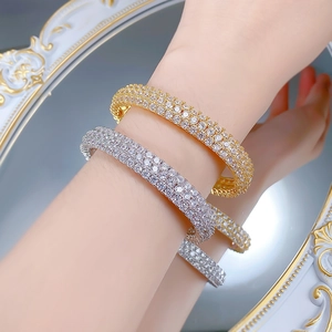 Macro detail of luxury wide bangles with full pavé cubic zirconia in gold and silver