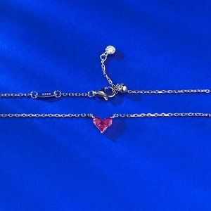 Collana in argento S925 con gemma a cuore color magenta su sfondo di seta blu scuro elegante