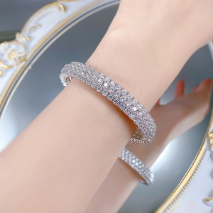 Detailed view of luxury silver-toned wide bangle paved with multi-row glittering crystals