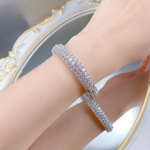 Close-up of sparkling silver tennis bracelet with multi-row pavé-set zircons on a wrist