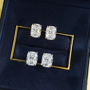 Macro detail of cushion-cut studs in gold and silver settings on blue velvet