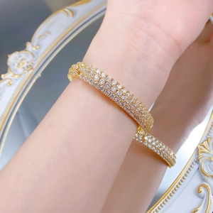 Close-up of gold-plated bracelet featuring three rows of micro-pave cubic zirconia crystals