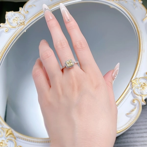 Close-up of S925 silver ring featuring a cushion-cut yellow gemstone and diamond halo