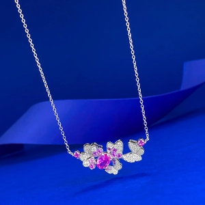 Macro detail of silver butterfly pendant with pink oval gem and shimmering crystals