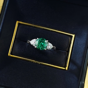 Elegant 2ct green emerald-cut crystal ring with pear-shaped side stones in a blue gift box