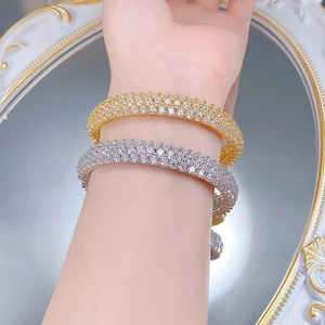 Close-up of gold and silver plated bangles with three rows of micro-paved cubic zirconia