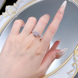Detailed view of S925 silver ring with pink princess cut gemstone on a hand