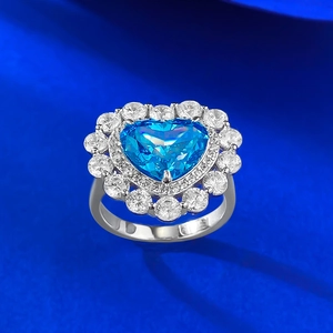 Macro d'une bague en argent S925 avec pierre bleue en cœur et halo de diamants brillants