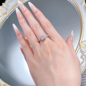 Close-up of a square princess cut pink diamond ring with micro-pave silver setting on a hand