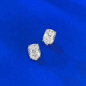 Close-up of cushion-cut white zircon earrings with classic four-prong silver setting