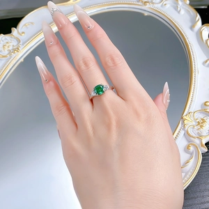 Close-up of a vintage S925 silver ring featuring a 2ct green emerald-cut center stone