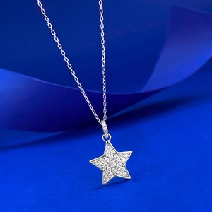 Collana con ciondolo a stella in argento S925 con pavé di diamanti su sfondo di seta blu