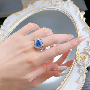 Détail d'une bague en argent S925 avec saphir bleu en forme de cœur et halo de diamants