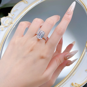 Macro shot of silver ring featuring a large emerald cut gemstone and micro-pave diamonds