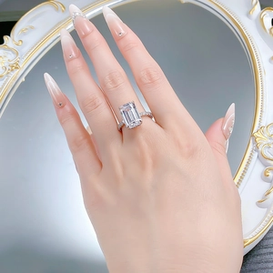 Macro view of emerald cut gemstone ring with silver band reflected in a mirror