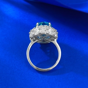 Close-up of S925 silver ring featuring intricate hollow flower pattern and oval blue gemstone