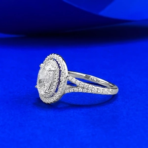 Macro detail of oval halo ring with sparkling pavé split shank in silver finish