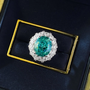 Luxurious S925 silver halo ring with large oval green gemstone in a blue velvet box