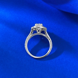 Macro detail of silver ring with oval halo setting on blue silk fabric background