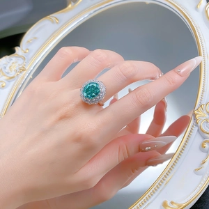 Detailed view of luxury oval green gemstone ring with double-layer halo diamond setting
