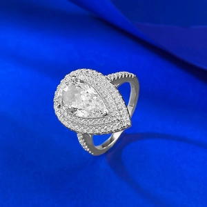 Macro detail of pear-shaped teardrop silver ring with double halo diamond pave setting