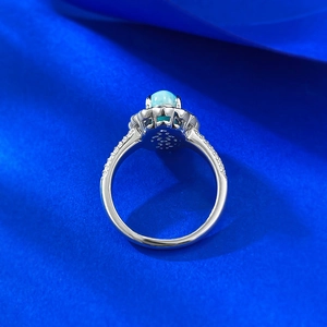 Vue rapprochée d'une bague Larimar avec halo de zircon sur velours sombre