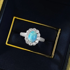 Bague Larimar ovale avec halo de pétales et pavé dans un écrin en velours