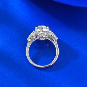 Macro shot of silver bow knot ring with large round solitaire on blue silk