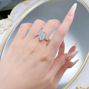 Macro shot of 925 silver ring featuring emerald cut center stone and side baguette diamonds
